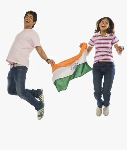 Couple holding Indian flag and jumping — Stock Photo, Image