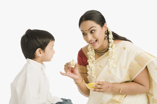 Woman feeding her son — Stock Photo, Image