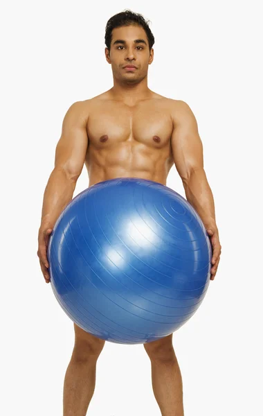 Человек держит фитнес-мяч — стоковое фото