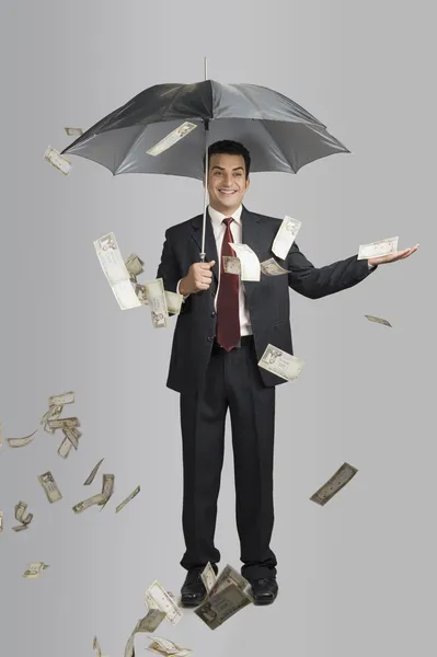 Dinero lloviendo sobre un hombre de negocios — Foto de Stock