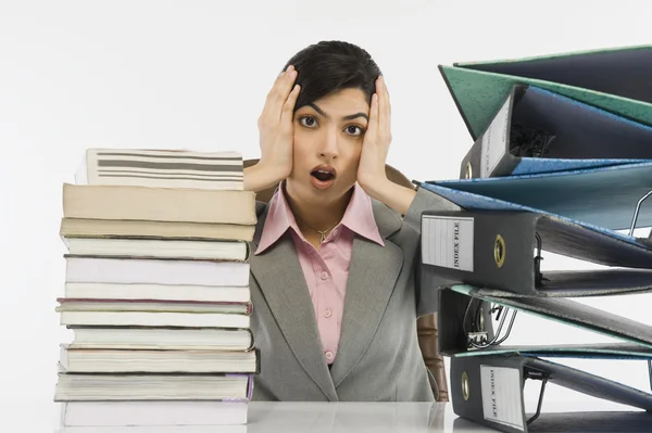 Stack of books and binders in front of a businesswoman — Stock Photo, Image