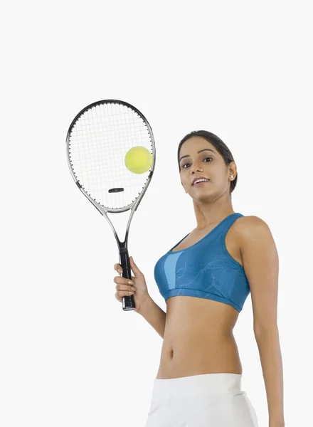 Mulher segurando uma raquete de tênis com uma bola — Fotografia de Stock