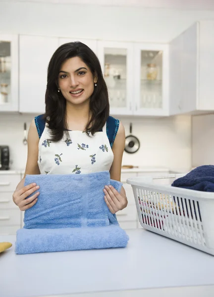Woman folding laundry — Stock Photo, Image