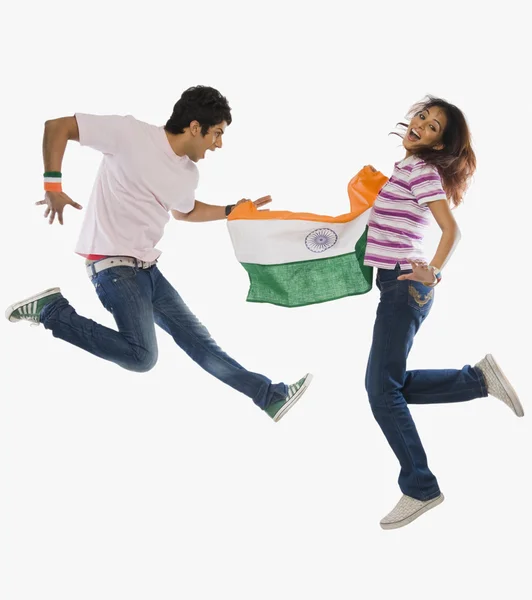 Couple holding Indian flag and jumping — Stock Photo, Image