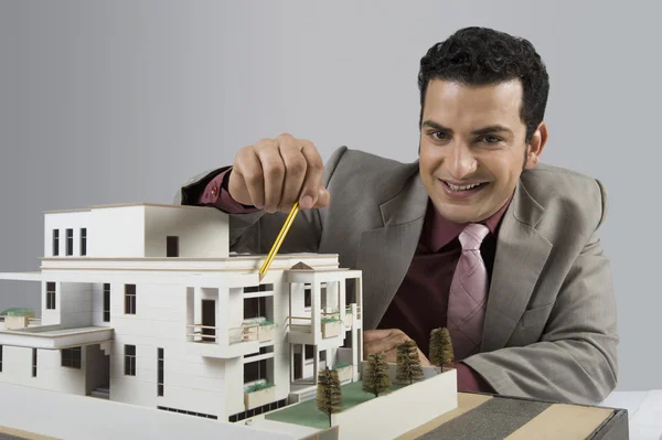 Architect with a model home in an office — Stock Photo, Image