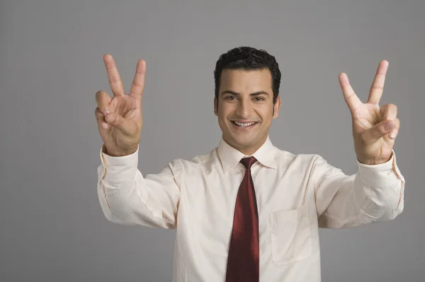 Retrato de um homem de negócios mostrando sinal de vitória — Fotografia de Stock