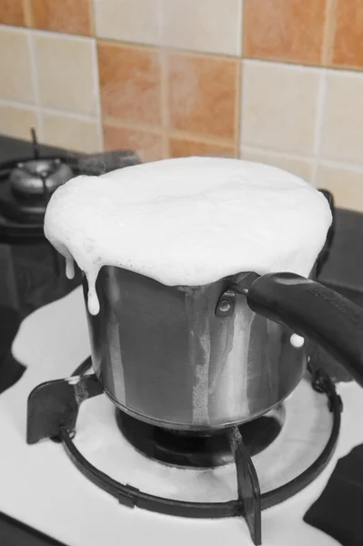 Milk boiling over a pan — Stock Photo, Image