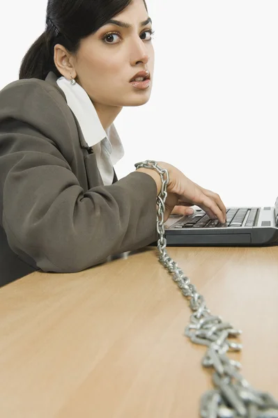 Businesswoman chained to her desk — Stock Photo, Image
