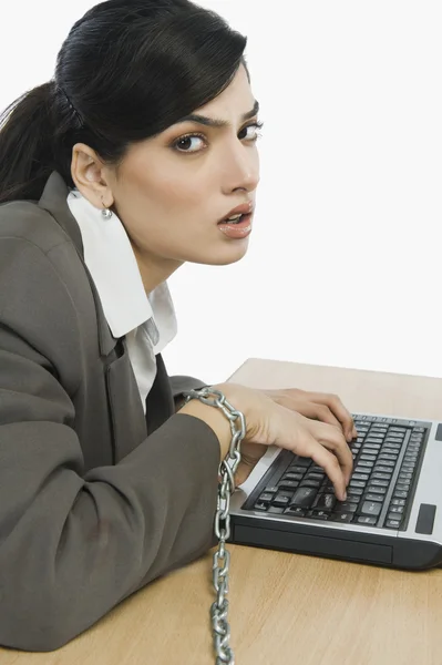 Affärskvinna fastkedjad vid hennes skrivbord — Stockfoto