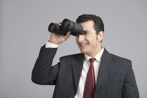 Empresario mirando a través de prismáticos — Foto de Stock