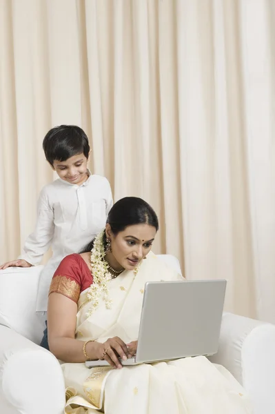 Mulher usando um laptop com seu filho — Fotografia de Stock