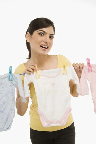Žena visící oblečení na prádelní šňůru — Stock fotografie