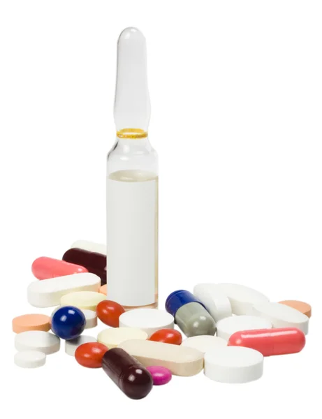 Close-up de comprimidos variados com um frasco para injetáveis — Fotografia de Stock