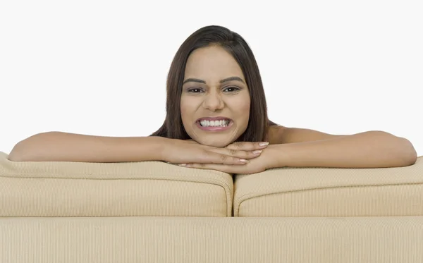 Woman leaning on a couch — Stock Photo, Image