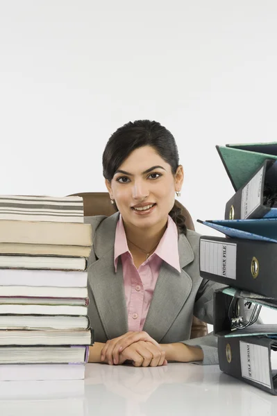 Stack of books and binders in front of a businesswoman — Stock Photo, Image