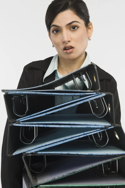 Businesswoman holding stack of binders — Stock Photo, Image