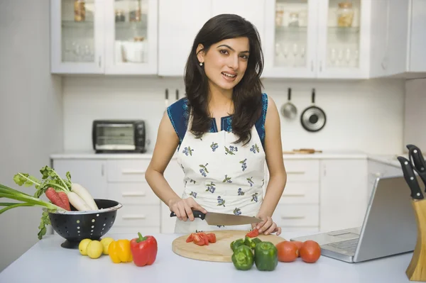 Žena sekání rajčata v kuchyni — Stock fotografie