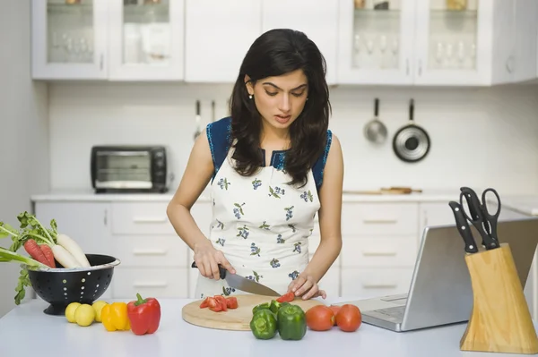 Vrouw hakken tomaten in de keuken — Stockfoto