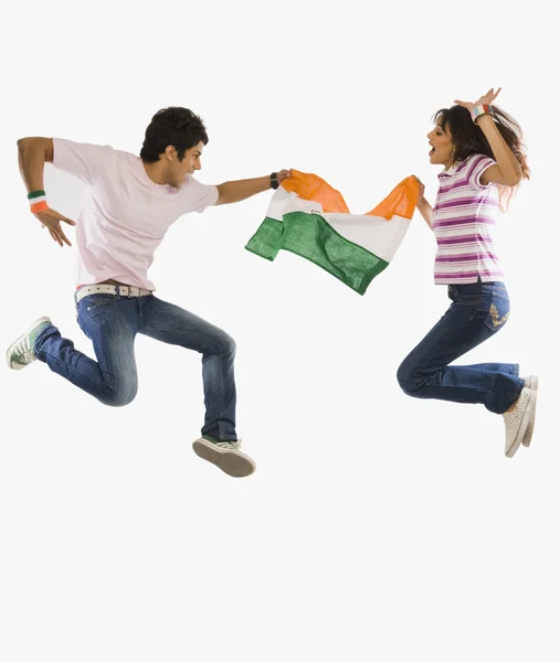 Couple holding Indian flag and jumping — Stock Photo, Image