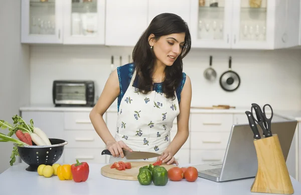 Mulher cozinhar com a receita em um laptop — Fotografia de Stock