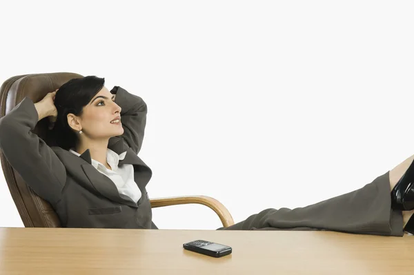 Zakenvrouw met voeten omhoog op een bureau — Stockfoto