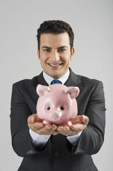 Retrato de um empresário segurando um banco porquinho — Fotografia de Stock