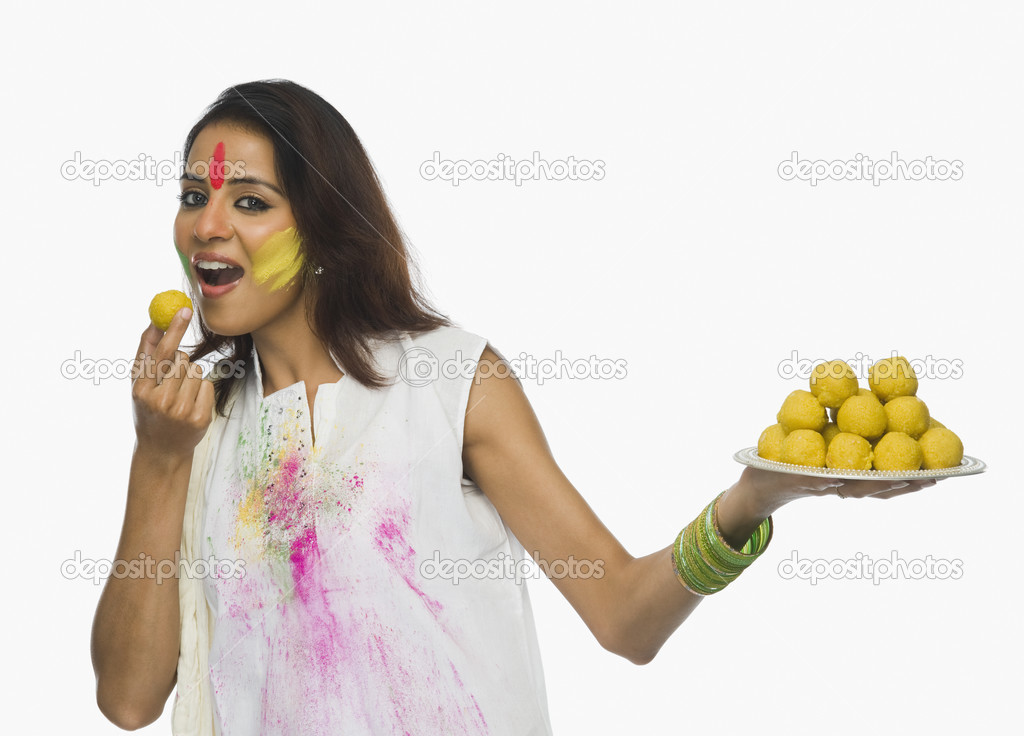 Woman eating Laddu on Holi