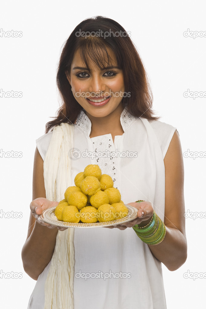 Woman holding Laddu in a plate on Holi
