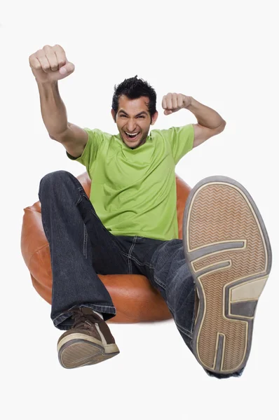 Man cheering on a bean bag — Stock Photo, Image