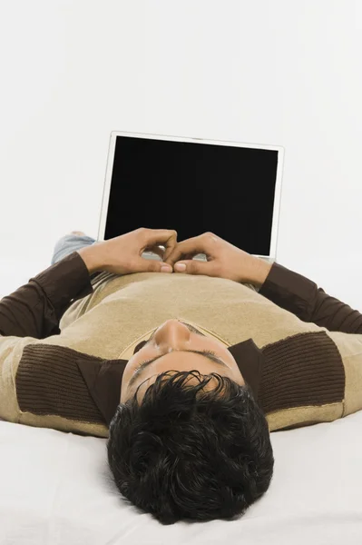 Muž leží na posteli s notebookem — Stock fotografie