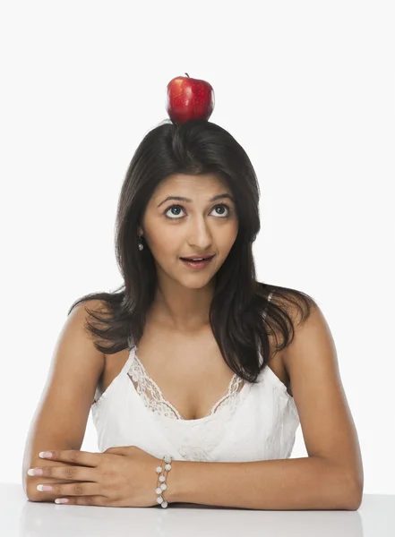 Woman balancing an apple on her head — Stock Photo, Image