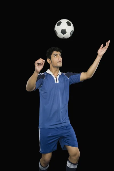 Soccer player practicing heading the ball — Stock Photo, Image