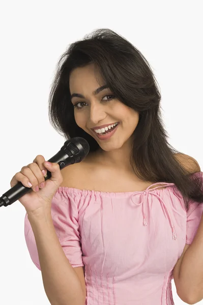 Mujer cantando en un micrófono — Foto de Stock