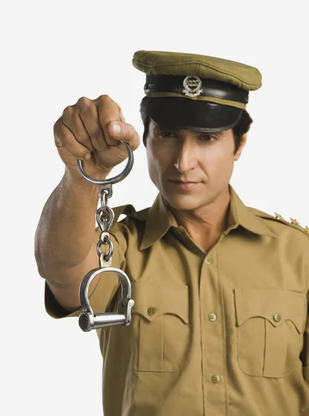 Policeman holding a pair of handcuffs — Stock Photo, Image