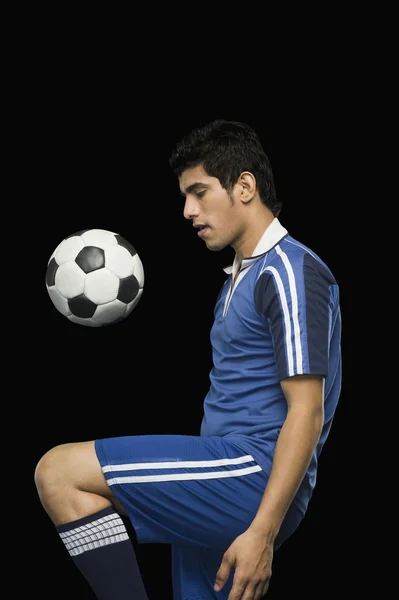 Jugador de fútbol practicando con una pelota de fútbol —  Fotos de Stock