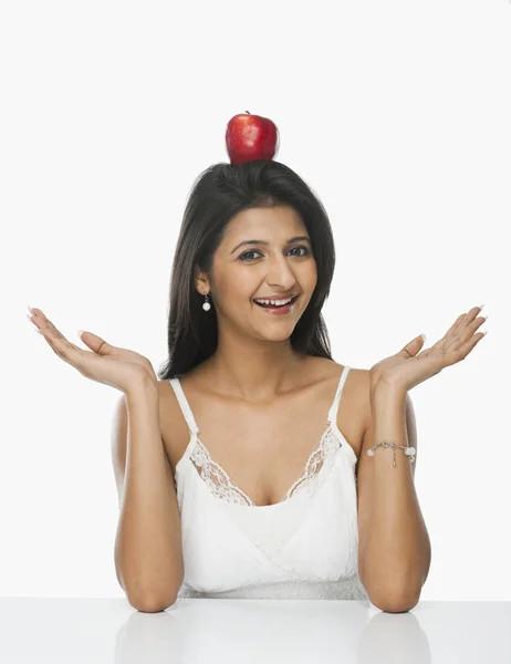 Woman balancing an apple on her head — Stock Photo, Image