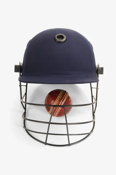 Cricket ball under a cricket helmet — Stock Photo, Image