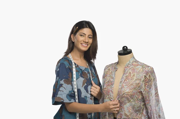 Fashion designer trying a dress on a mannequin — Stock Photo, Image