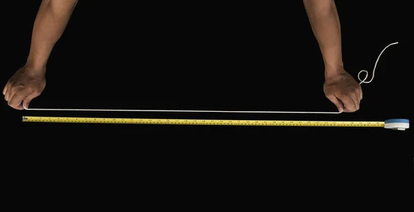 Man measuring string with a tape measure — ストック写真