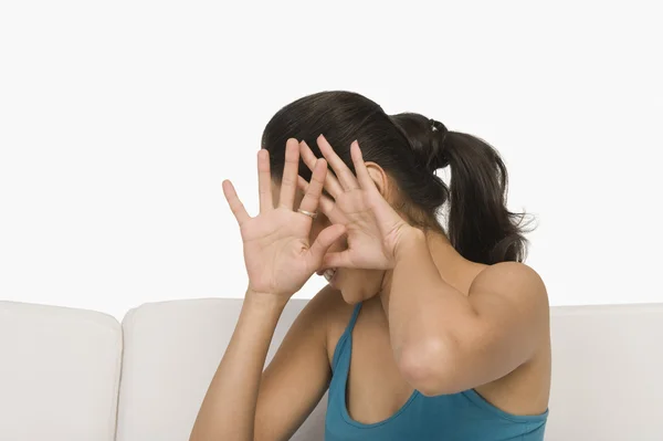 Kvinna som täcker hennes ansikte med händerna — Stockfoto