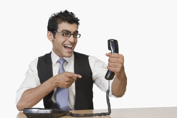 Empresario apuntando a un receptor telefónico — Foto de Stock