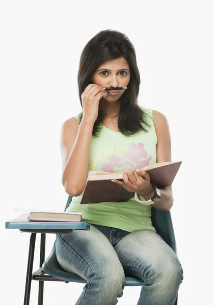 Student holding a pen as mustache — Stock Photo, Image