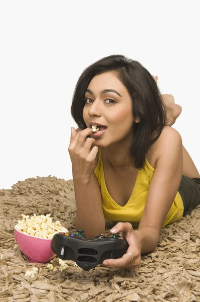 Woman eating popcorn and playing video game — Stock Photo, Image