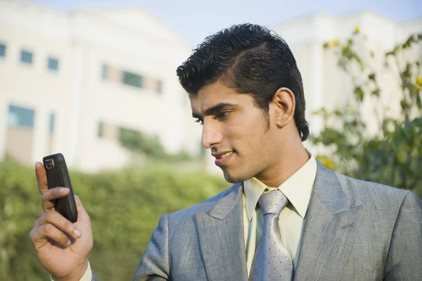 ビジネスマン テキスト ・ メッセージング、携帯電話を — ストック写真