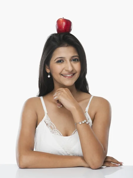 Woman balancing an apple on her head — Stock Photo, Image