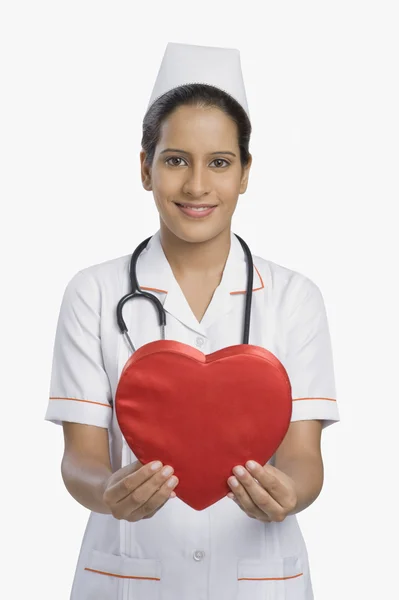 Enfermeira segurando uma forma de coração — Fotografia de Stock