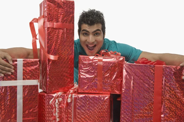 Mann hält Geschenkboxen in der Hand und schaut aufgeregt — Stockfoto