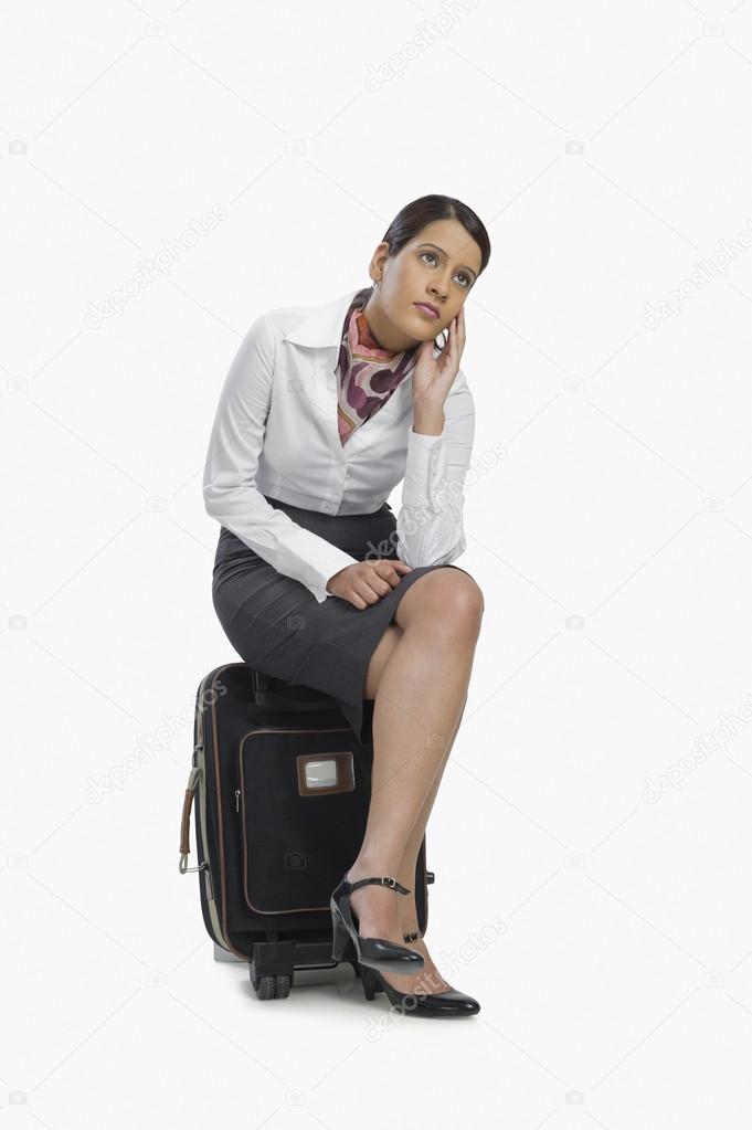 Air hostess sitting on her luggage