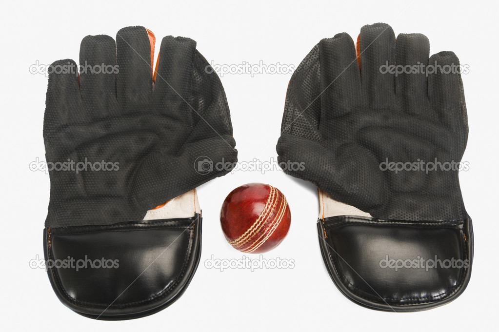 Cricket ball with a pair of wicket keeping gloves