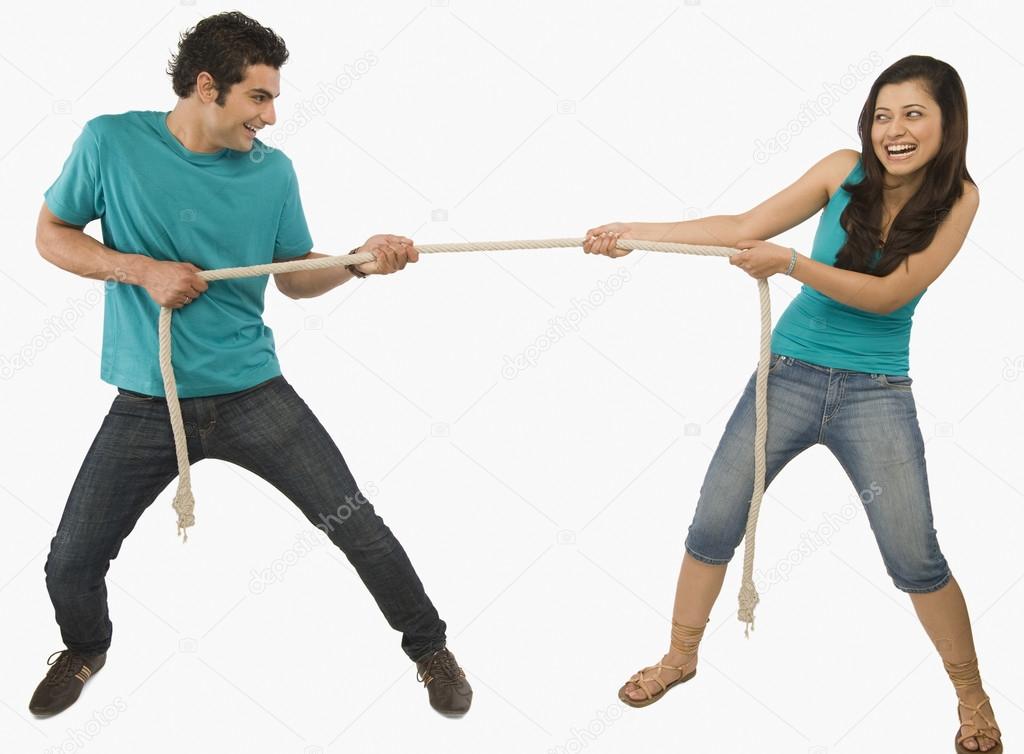 Young couple playing tug of war
